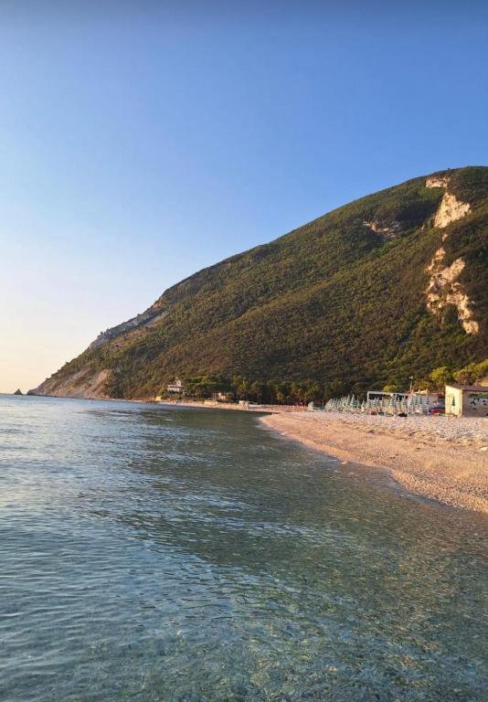 a view of a beach with a hill in the background at La casa di Pi in Montacuto
