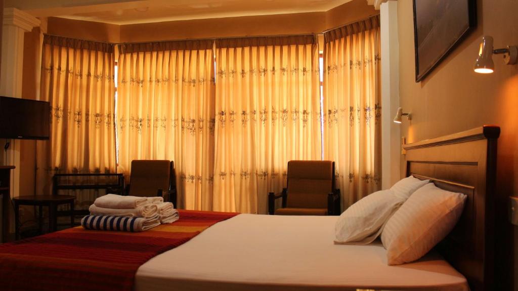 Postel nebo postele na pokoji v ubytování Janishi Residencies