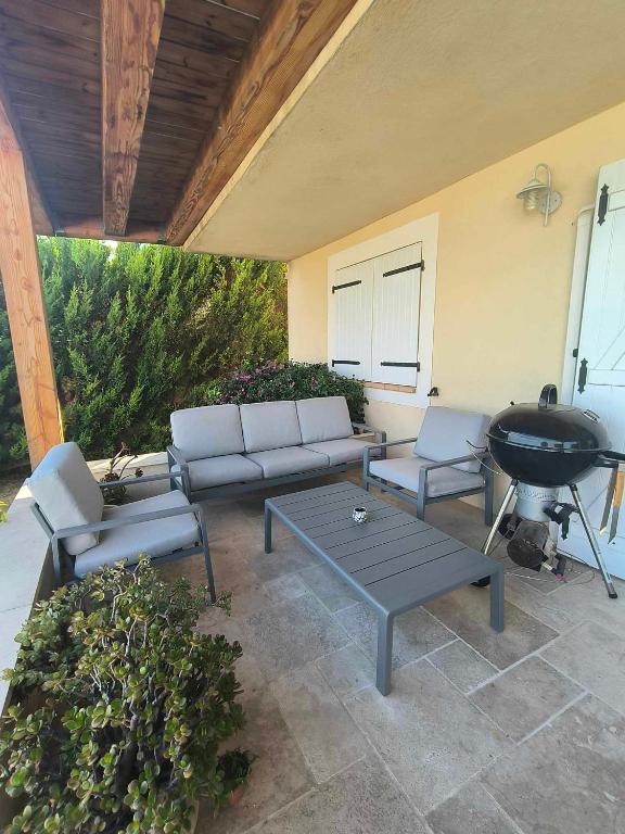 une terrasse avec un canapé, une table et un grill dans l'établissement Bas de villa chez Marta, à Antibes