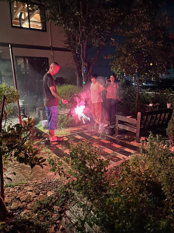 un gruppo di persone in piedi in un cortile con una scintilla di ヨーコのお宿 わくわく a Toyama