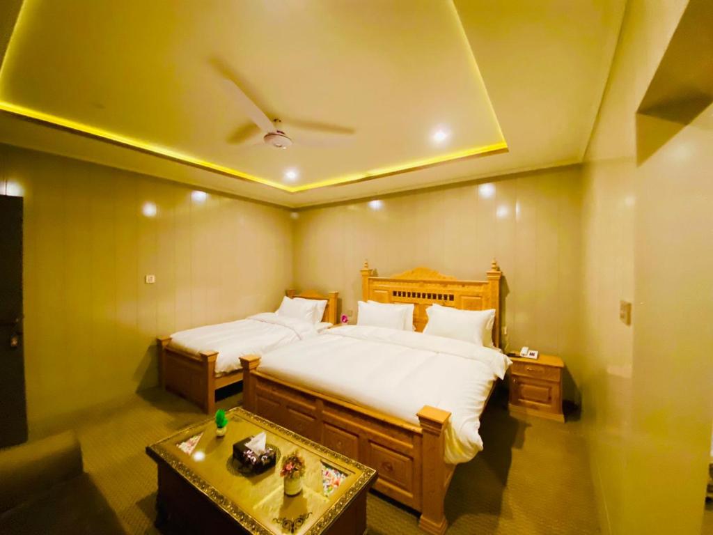 a bedroom with a large bed with a ceiling at Hotel Blangsa Indus View in Skardu