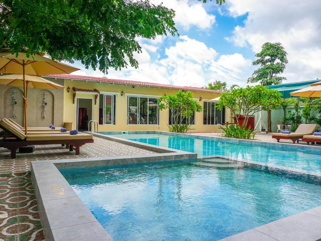 a swimming pool in front of a house at Le Kree Downtown Hotel in Phnom Penh