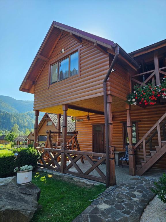 a wooden house with a porch and a balcony at Guesthouse Kolo Druziv in Tatariv