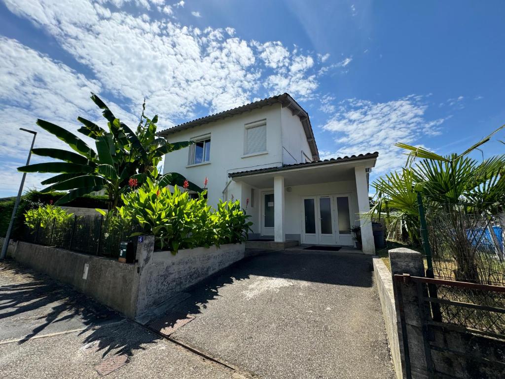 ヴィルヌーヴ・シュル・ロットにあるVilla des palmiersの塀と植物のある白家