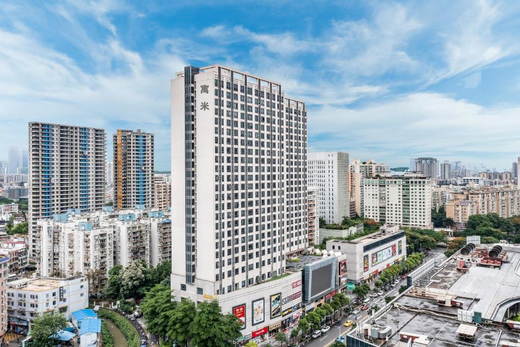 un alto edificio nel mezzo di una città di 寓米公寓(琶洲会展中心广州塔店) a Canton
