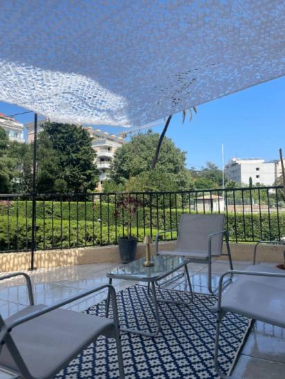 un patio avec des chaises, une table et un parasol dans l'établissement Appartement Rooftop Cannes, à Cannes