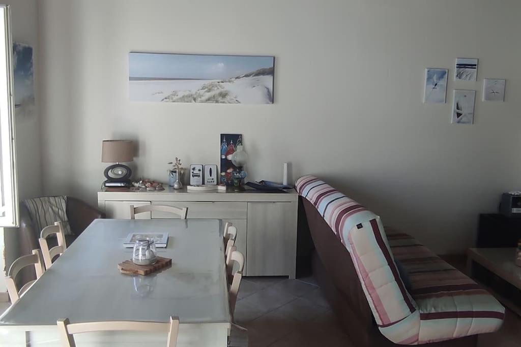 une salle à manger avec une table et un canapé dans l'établissement Maison de vacances, au Guilvinec