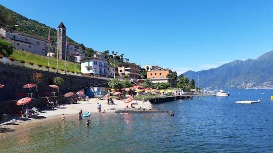ein Strand mit Sonnenschirmen und Menschen im Wasser in der Unterkunft Casa Lido San Nazzaro in San Nazzaro