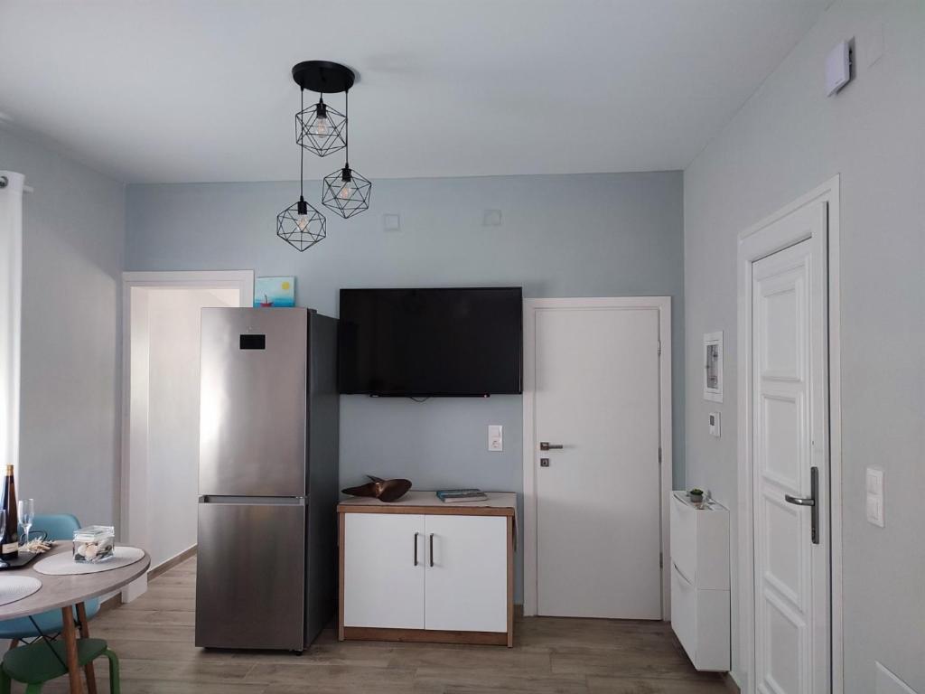 a kitchen with a stainless steel refrigerator and a table at Little Dream House in Valanidorachi
