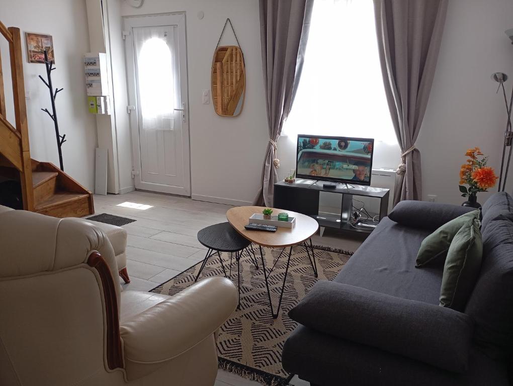 a living room with a couch and a table at Appart Maison de ville in Bourges