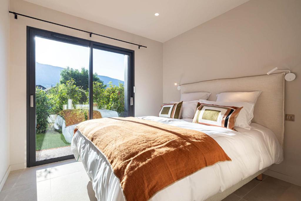 una camera da letto con un letto grande e una grande finestra di La Villa 225 - Lac Annecy a Saint-Jorioz