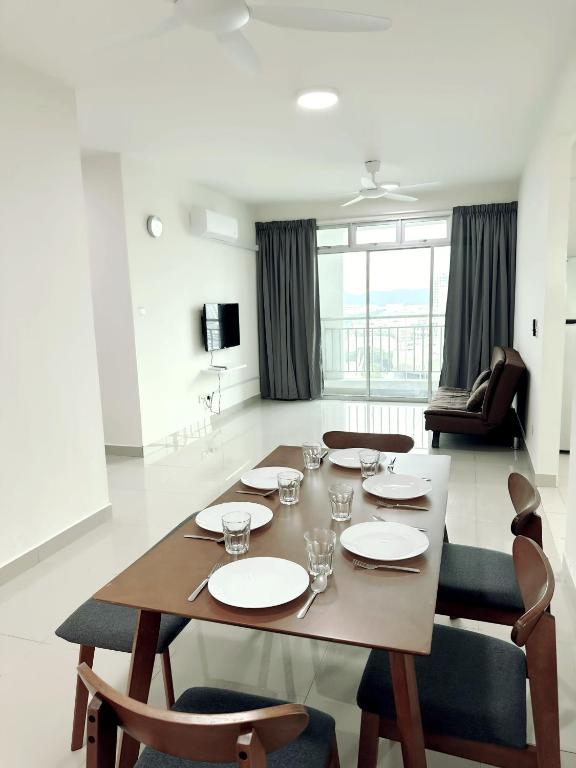 ein Esstisch und Stühle in einem Wohnzimmer in der Unterkunft Tur16 SPlCE 10pax 4room Private House in Bayan Lepas