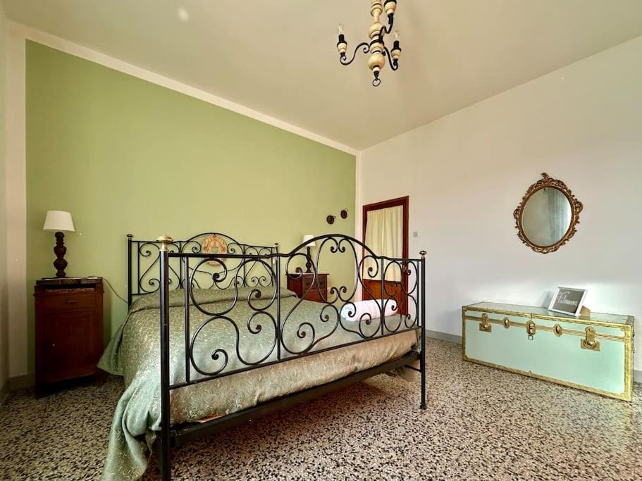 a bedroom with a bed and a mirror on the wall at Podere Casa Rossa a Pienza in Pienza