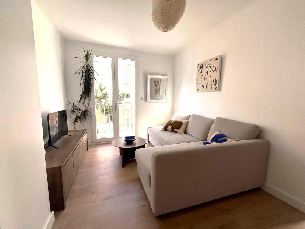 un salon avec un canapé et une télévision dans l'établissement La plage à 80m, refait à neuf, à Marseille