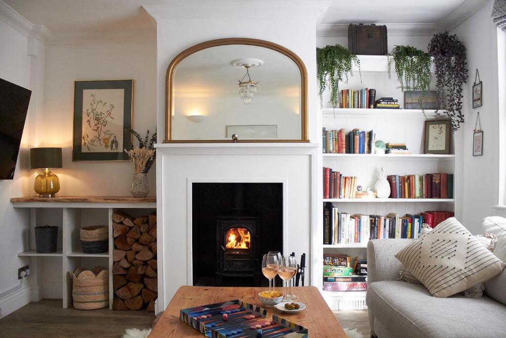 a living room with a fireplace and a table at Earl Cottage, Woodbridge in Woodbridge