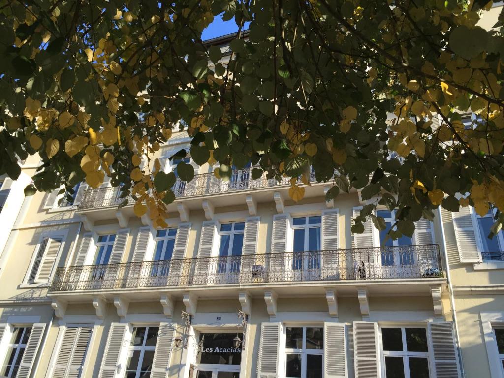 un edificio blanco con ventanas y balcones en Acacias Apparts Hotel, en Plombières-les-Bains