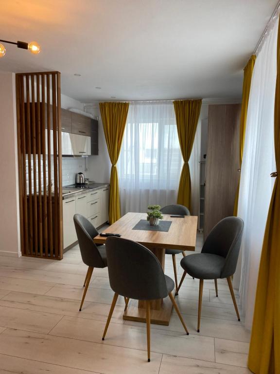 a kitchen and dining room with a table and chairs at Wonderland apartment in Bistriţa
