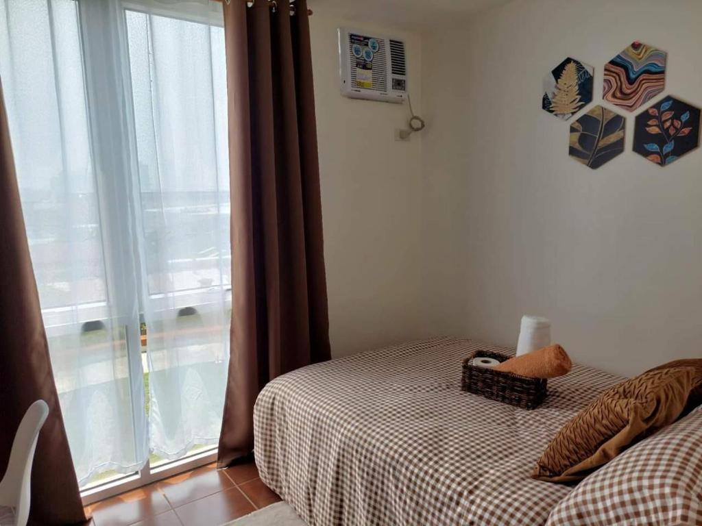a bedroom with a bed and a window at Chill Spot Staycation in Pasig in Manila