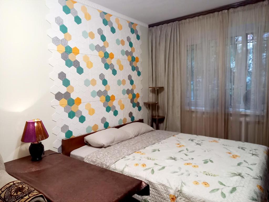 a bedroom with a bed and a colorful wall at "Ботанический сад" Тихий район Квартира in Almaty