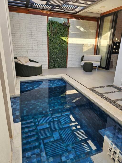 a swimming pool with blue tile in a house at Casa Ideal e Confortável in Sinop