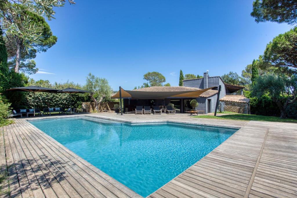 une piscine avec une terrasse et une maison dans l'établissement Villa Deluxe Piscine Privative 8 couchages, à Saint-Raphaël