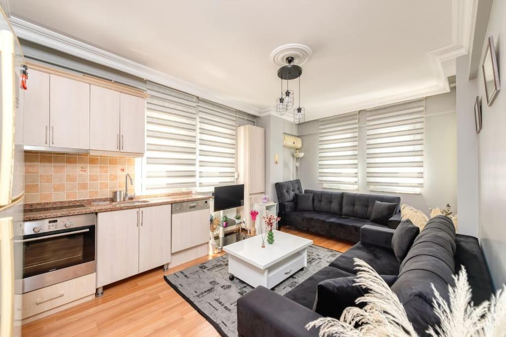 a living room with a black couch and a kitchen at Qbra House 2BR Central Apt Walk to Landmarks in Istanbul