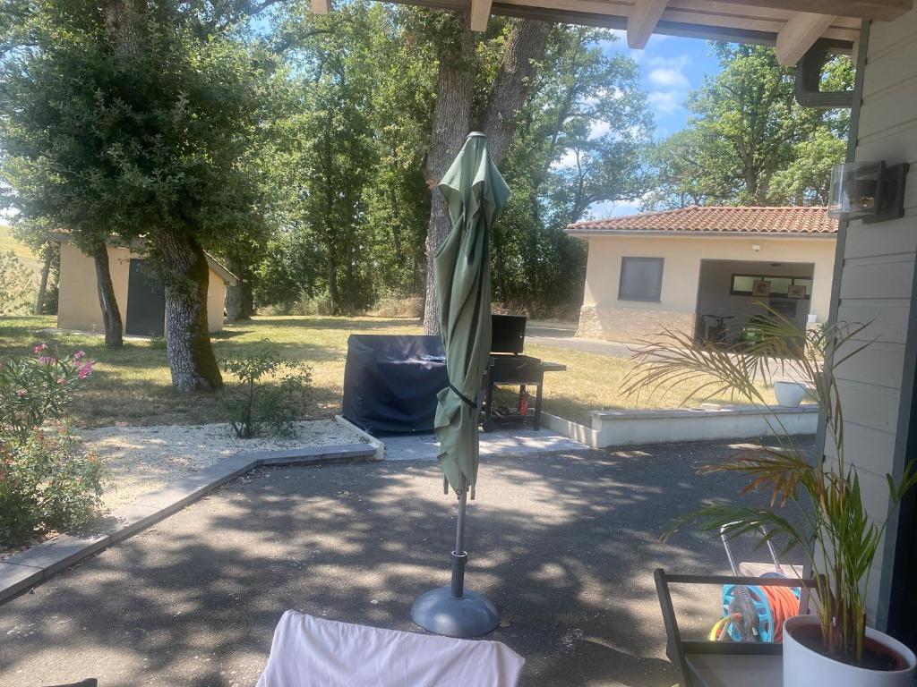 un parasol fermé assis sur une table dans une cour dans l'établissement Villa moderne, à Monfort