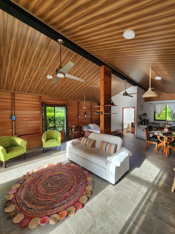 a living room with a white couch and a table at Romantic Cabin in the Forest, Valle Azul, Bungalows Tulipanes CR in San Ramón