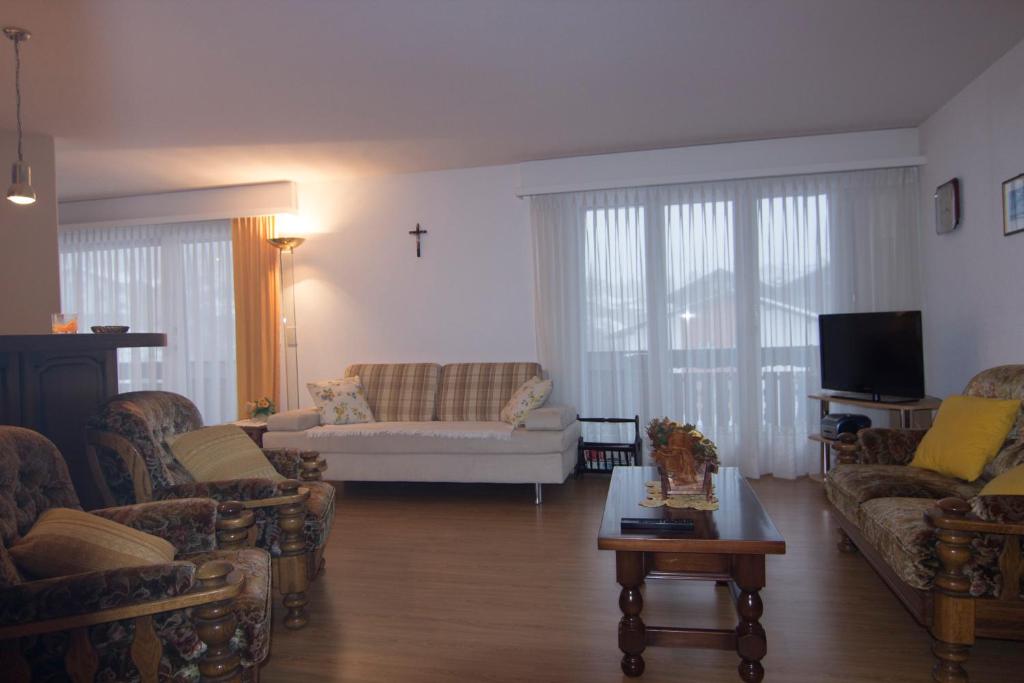 a living room with couches and a cross on the wall at Waldrain 2 in Saas-Fee