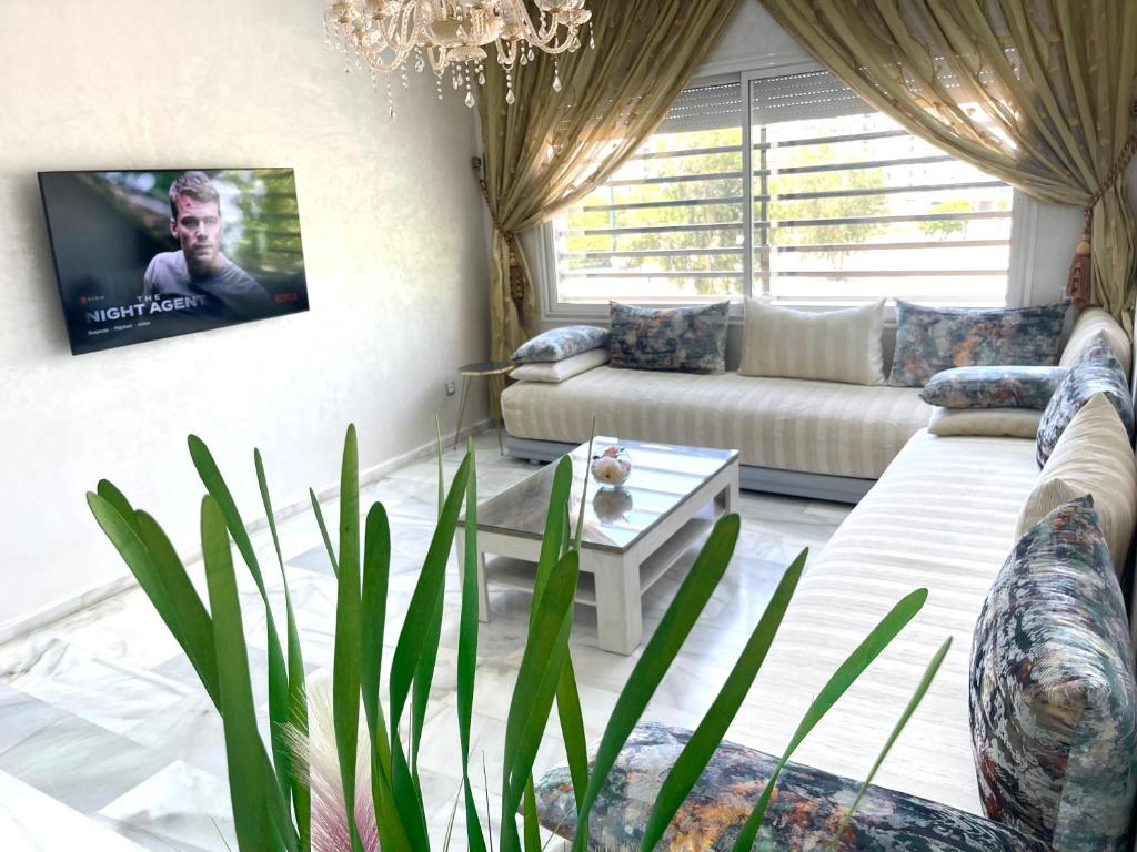 a living room with a couch and a tv at Luxueux Appartement Parc Champs de Cours avec Wifi Fibre 200 Mo in Fès