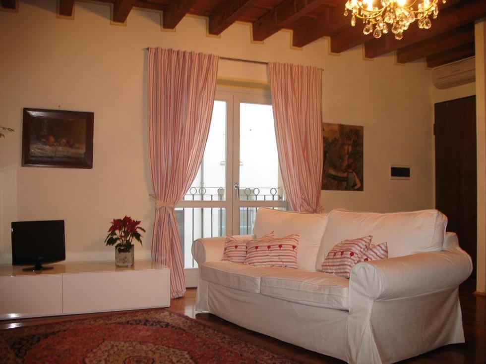 een woonkamer met een witte bank en een raam bij B&B A Casa Di Andrea in Mantova