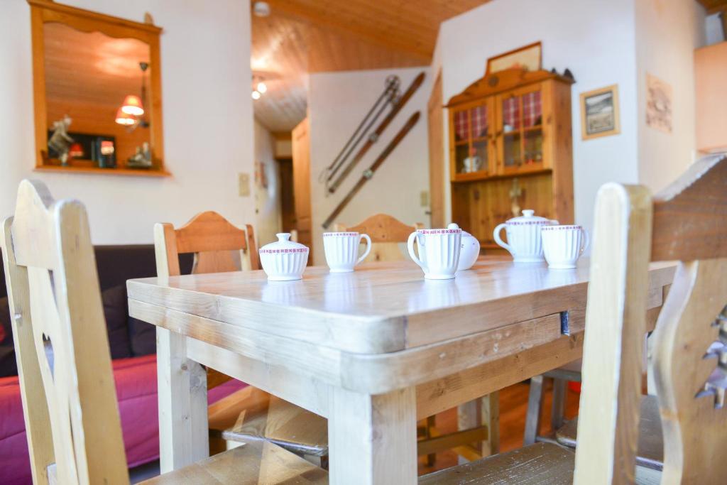 a wooden table with white bowls on top of it at VALLOIRE - Les Verneys - Thymel in Valloire