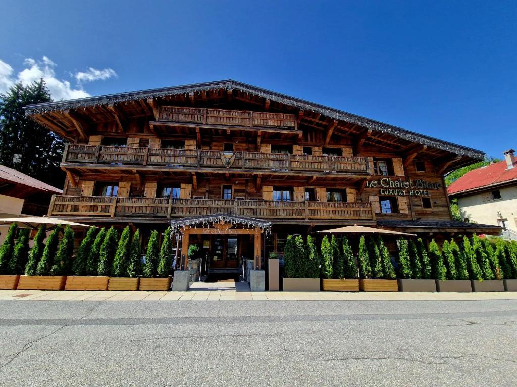 a large wooden building with a balcony on top at Le Chalet Blanc in Megève
