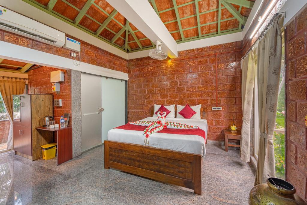 a bedroom with a bed and a brick wall at Nathan Resort with Swimming Pool in Puducherry