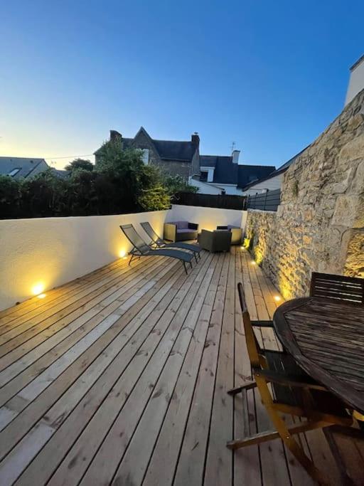 une grande terrasse en bois avec des chaises et une table dans l'établissement Charmante Maison centre Bourg de crac'h Golf du morbihan, à Crach
