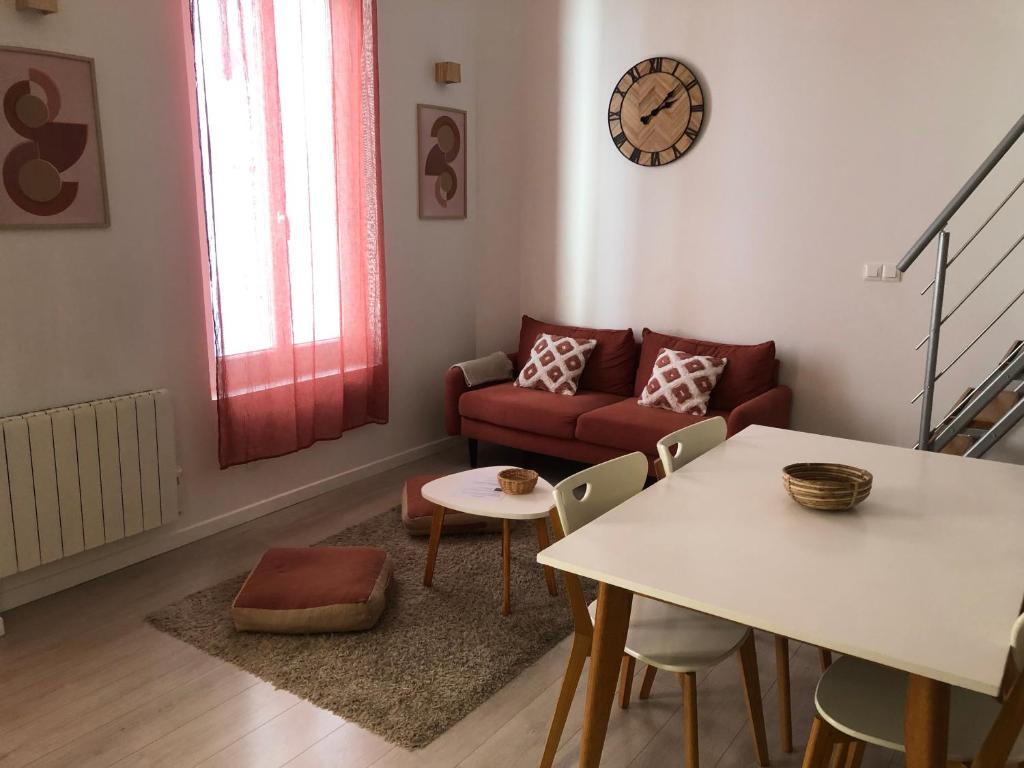 un salon avec une table et un canapé dans l'établissement Appartements coeur de ville de Vichy, à Vichy