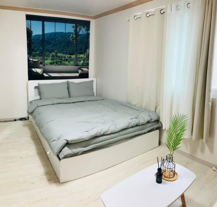 a white bedroom with a bed and a table at 1 min from Sadang Station line 2 & 4 in Seoul