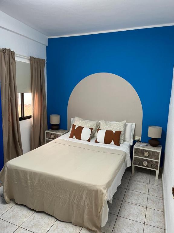 een slaapkamer met een groot bed met een blauwe muur bij CORNELIAS HOME 5A playa in Los Cristianos