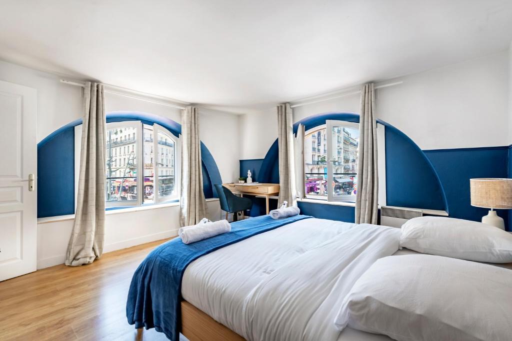 une chambre avec un grand lit et deux fenêtres dans l'établissement Close to Center of Paris I Fully equipped, à Paris