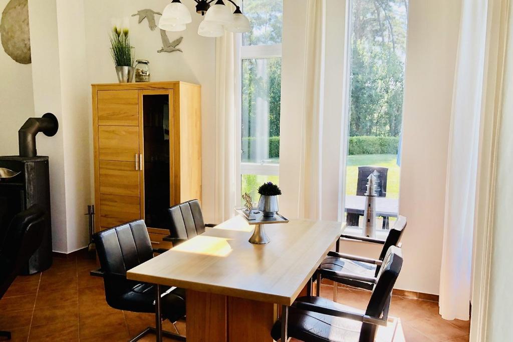 een eetkamer met een tafel en stoelen en een raam bij OstseeFreiheit in Bodstedt