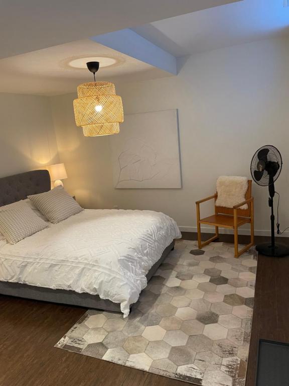 Un dormitorio con una cama, una silla y una lámpara. en Cozy and modern Pemberton Heights Suite, en North Vancouver