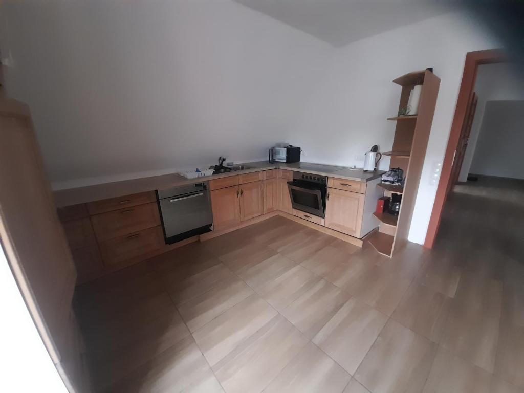 a kitchen with wooden cabinets and a wooden floor at Monteurzimmer KM in Delbrück