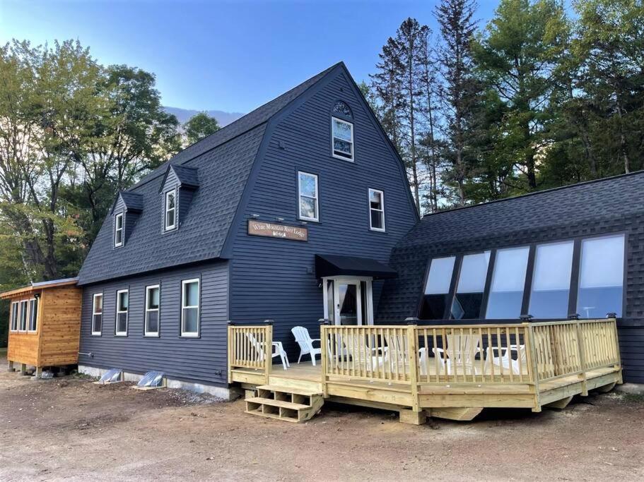 a large black house with a porch and a deck at RIVER! Hot tub, Movie theater, Sauna, Massage chair in Conway