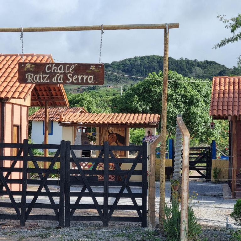 a gate with a sign in front of a restaurant at Chalé Raiz da Serra in Gravatá