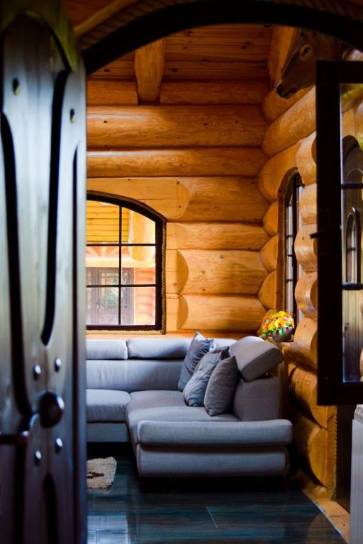 a living room with a couch in a log cabin at Cabana Ursilor in Vama