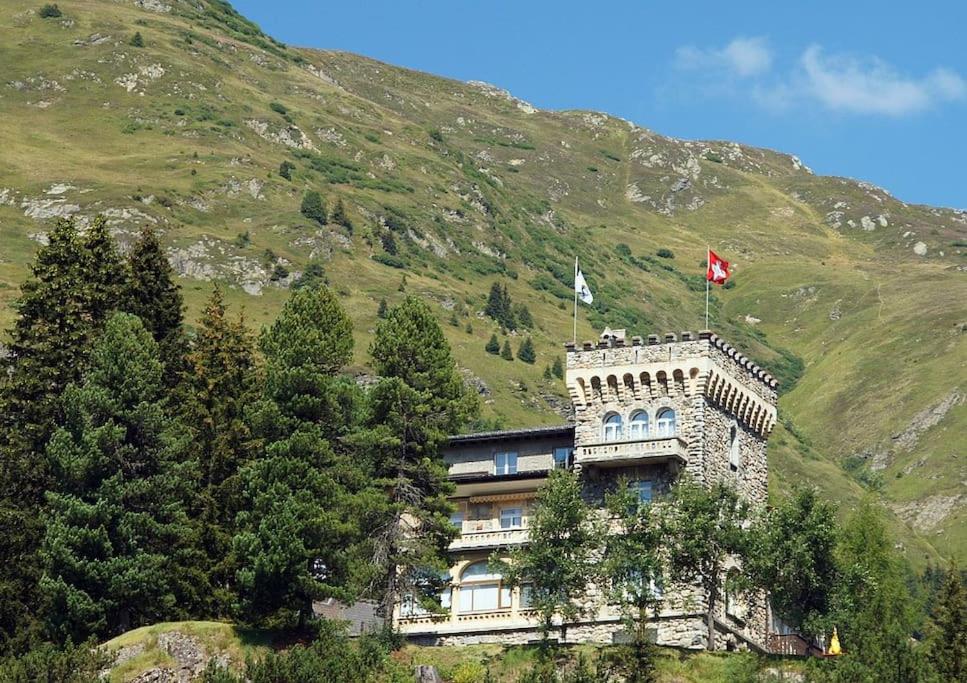 a building with two flags on top of a mountain at WEF 2026 Exclusive 160mq Castle Apartment in Davos -now available again in Davos