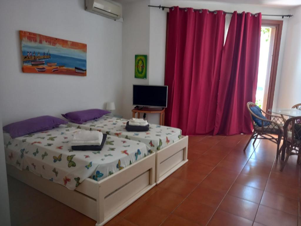 a bedroom with a bed and a tv in it at Appartamento t0 n 7 situato complesso turistico porto antico 2 in Santa Maria