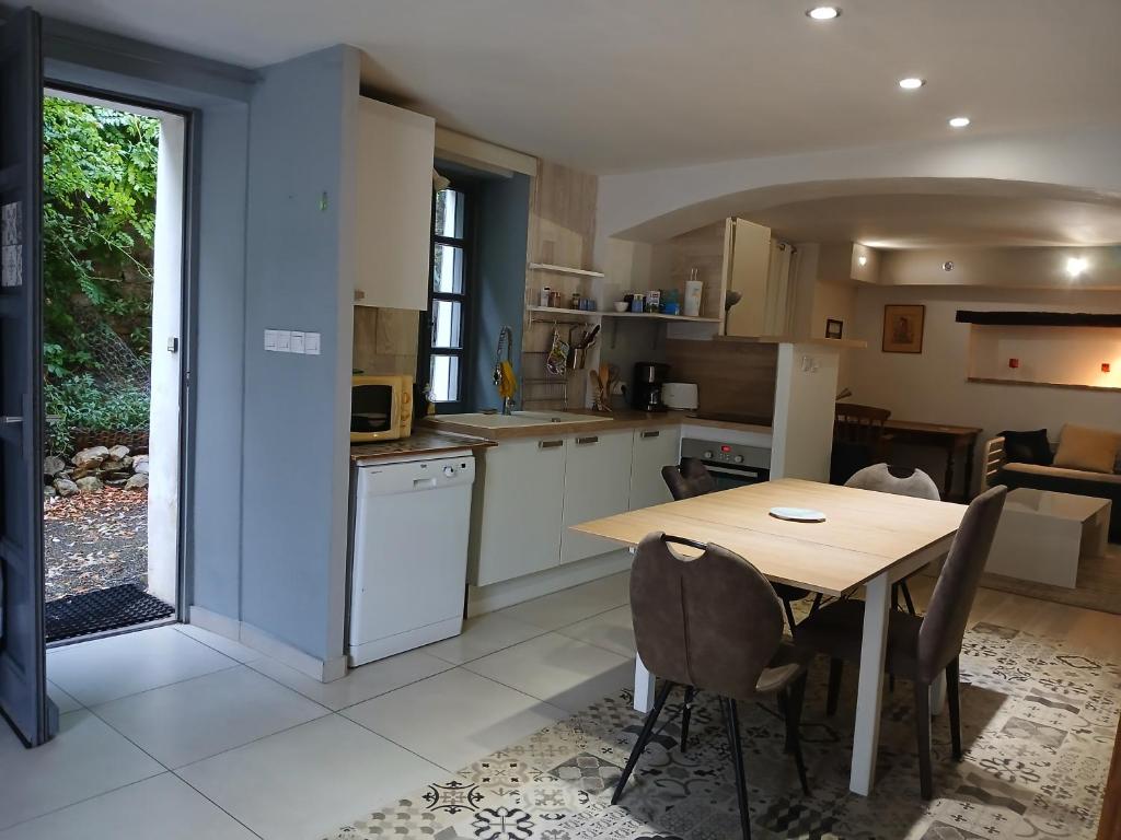 a kitchen and dining room with a table and chairs at Maison au pied du château, terrasse in Grignan