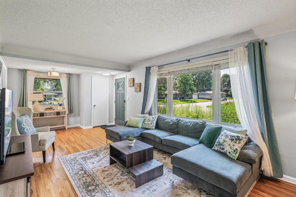 a living room with a couch and a large window at BeHome Your Cozy, Fun Getaway in Richfield