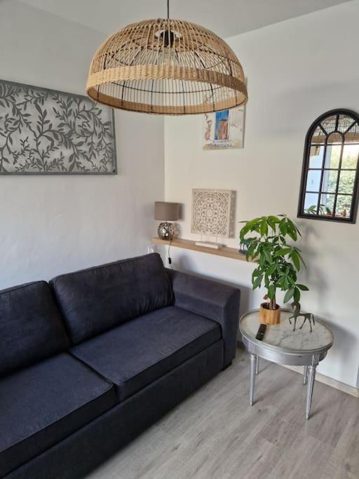 un salon avec un canapé bleu et une table dans l'établissement valras plage à 5 minutes de la mer, à Valras-Plage